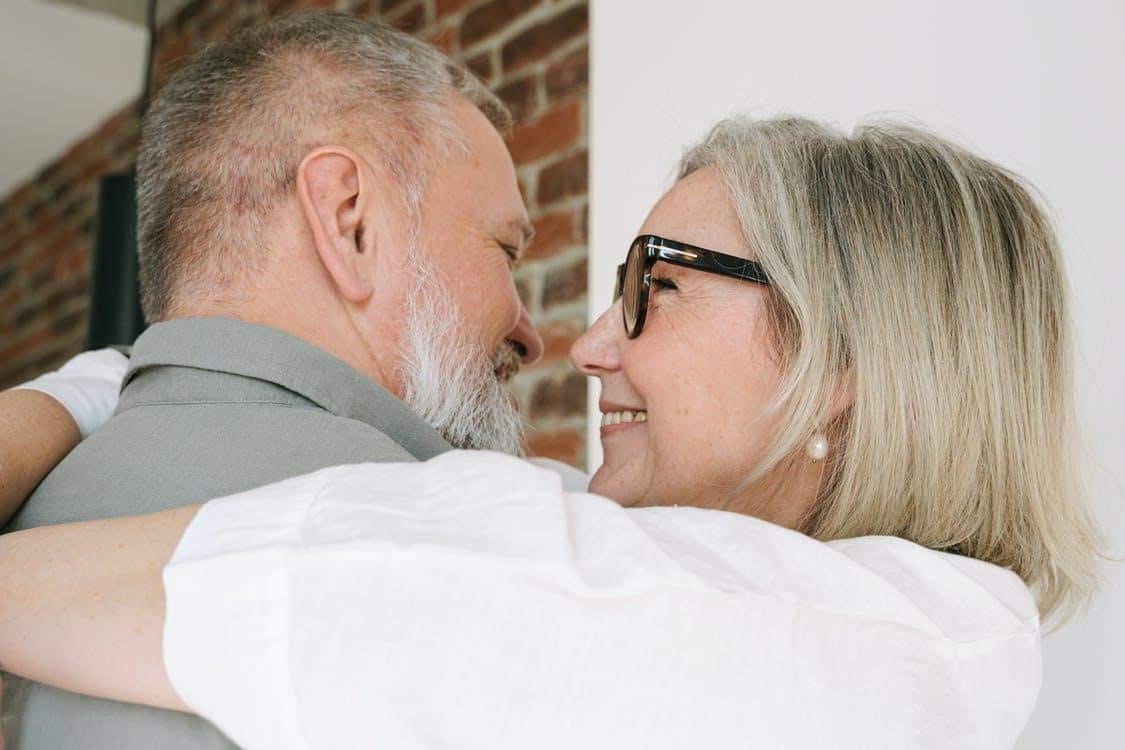 A Middle-Aged Woman Standing with Her Arms Around a Middle-Aged Man