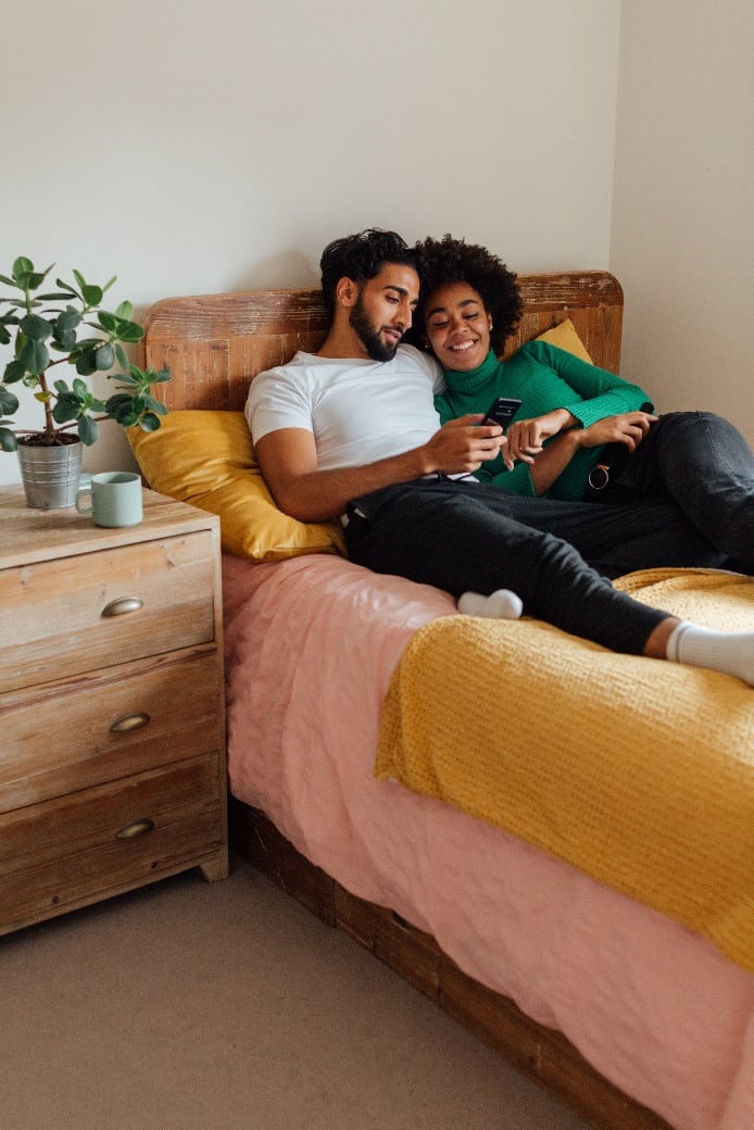 a happy couple lying on the bed